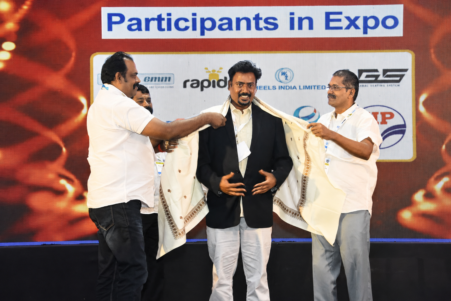 Dr. V. Amudhan being felicitated with a shawl at an industry expo